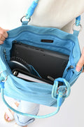 Woman holding a light blue Active Tote bag with shoulder strap and phone holder