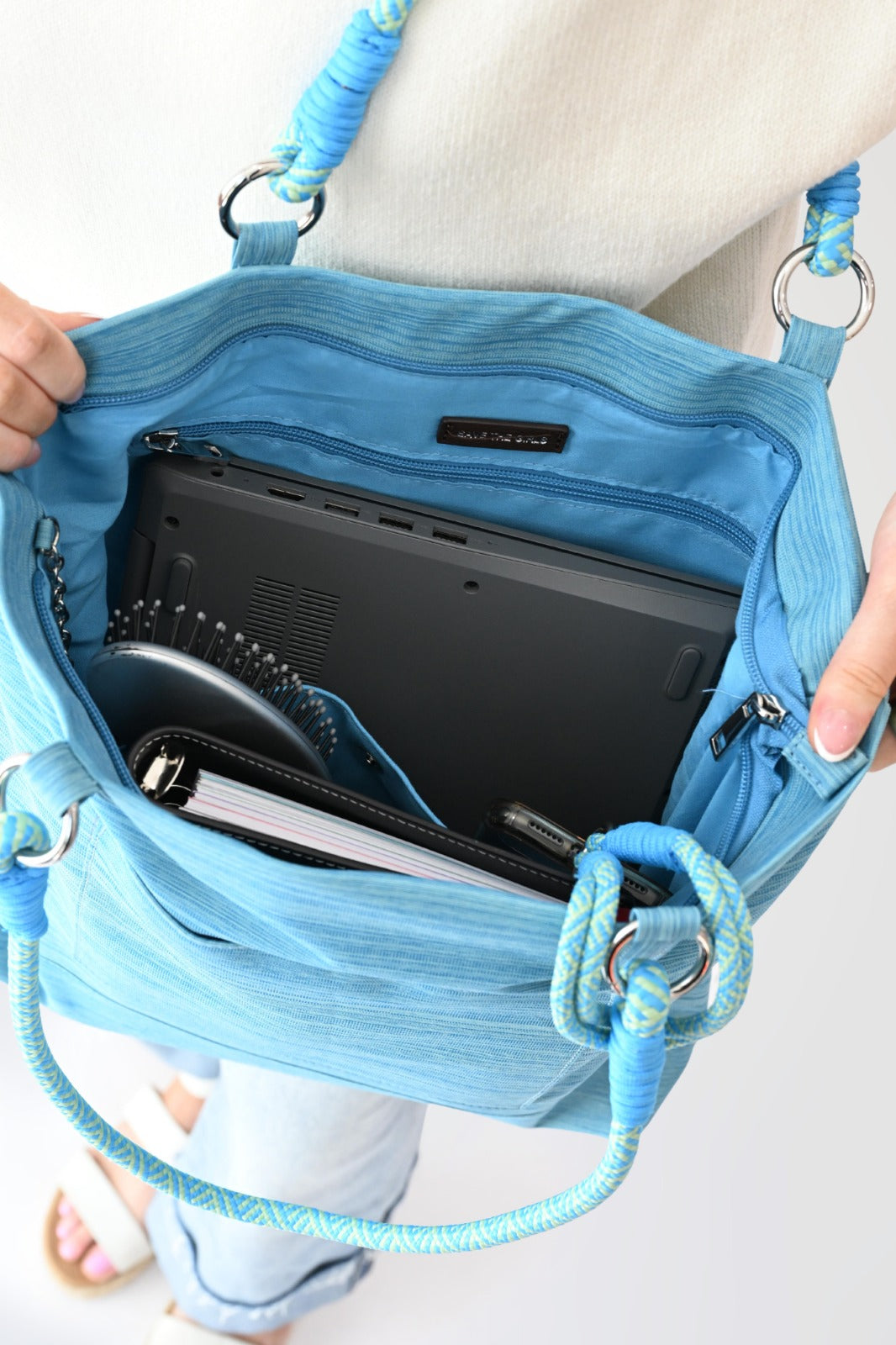 Woman holding a light blue Active Tote bag with shoulder strap and phone holder