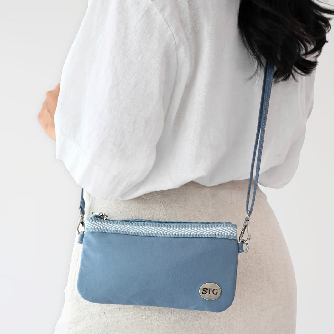 Woman holding a blue Active Catchy Clutch waterproof phone pouch