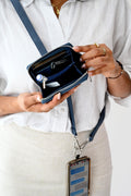 Woman wearing a blue Clip & Go vegan leather crossbody phone pouch with adjustable strap