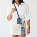 Woman wearing a blue Clip & Go vegan leather crossbody phone pouch with adjustable strap